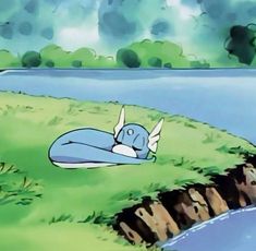 a cartoon character laying on the ground next to a body of water