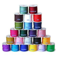 many colors of thread are stacked on top of each other in the shape of a pyramid