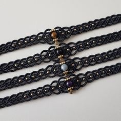 three black lace bracelets with beads on them