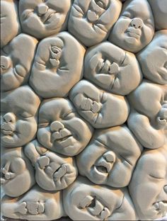 there are many faces carved into the side of a wall with different shapes and sizes