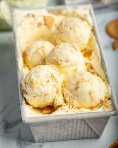 an ice cream dish with several scoops in it on a marble countertop next to other dessert items