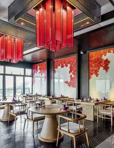 an empty restaurant with red lanterns hanging from the ceiling and wooden tables in front of large windows