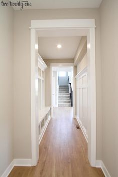 an empty hallway with wooden floors and white walls, leading to the second floor bedroom