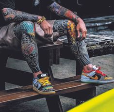 a man with tattoos sitting on a bench