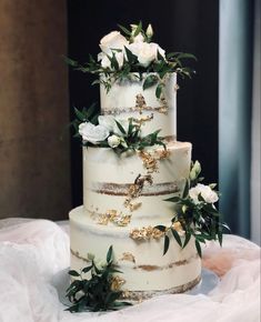 a wedding cake with white flowers and greenery