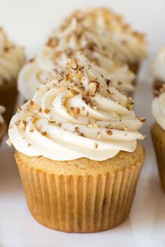 several cupcakes with white frosting and sprinkles