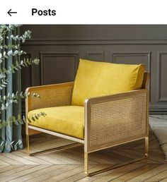 a yellow chair sitting on top of a hard wood floor next to a green plant