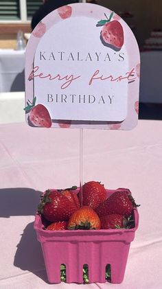 strawberries in a pink container on a table with a sign that says kaalayas berry puree birthday