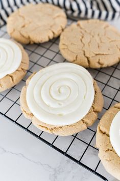 cookies with white frosting sitting on a cooling rack