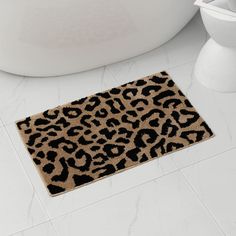 a leopard print rug on the floor next to a bathtub