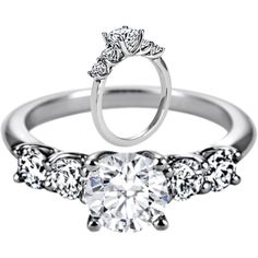 a white gold engagement ring with three stones on the side and a round brilliant diamond center