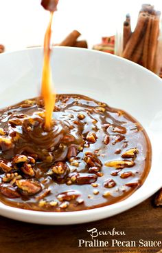 a white bowl filled with caramel pecan sauce on top of a wooden table