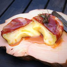 some food on a wooden plate with a knife and fork in the middle of it