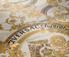 an ornate gold and white wallpaper with the word versa on it's side