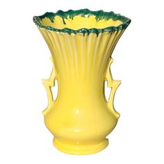 a yellow vase sitting on top of a white table