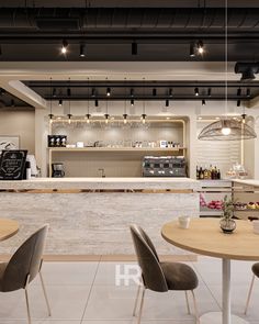 the interior of a restaurant with tables, chairs and counter top in front of it