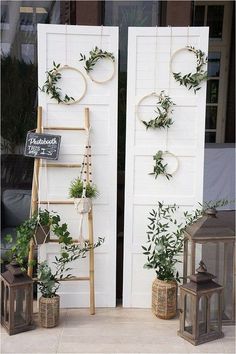 two wooden ladders with plants on them next to a white door and window display