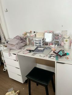 a white desk topped with lots of clutter on top of it's drawers