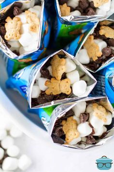 some cookies and marshmallows are wrapped in tinfoil on a plate with glasses