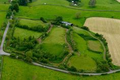 an aerial view of a green field and road