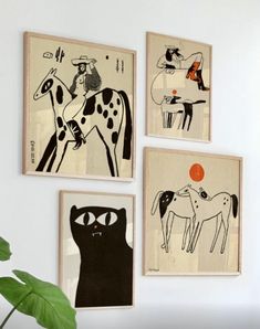 three framed art pieces hang on the wall next to a potted plant