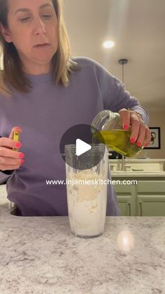 a woman is pouring something into a blender