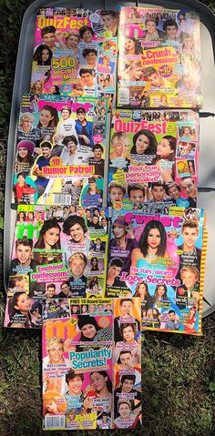 several magazines are laying on the ground in front of a trash can with pictures of people