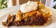 a piece of pie with ice cream on top is sitting on a plate next to a fork