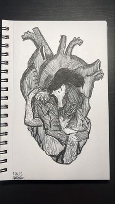 a drawing of a human heart on a piece of paper with the image of a woman hugging her head