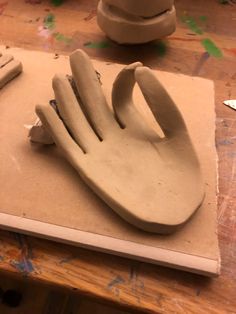 a close up of a clay sculpture on a table with scissors and paintbrushes