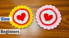 two crocheted coasters sitting on top of a wooden table