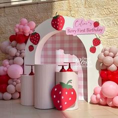 a strawberry themed birthday party with balloons and decorations