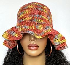 a mannequin head wearing a crocheted hat on top of a wig