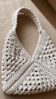 a white crocheted bag sitting on top of a table next to a window