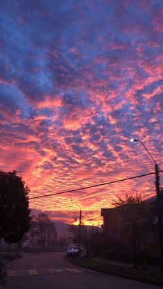 the sun is setting over an empty street