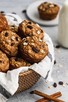 chocolate chip muffins in a basket next to cinnamon sticks and a glass of milk