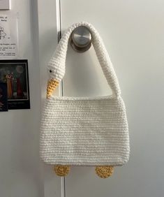 a crocheted purse hanging on the wall next to a doorknob with a handle