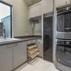 a kitchen with an oven, washer and dryer inside of it next to a window