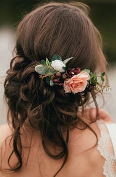 a woman with flowers in her hair wearing a flower headpiece on her wedding day