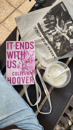 a book sitting on top of a wooden bench next to a cup and saucer