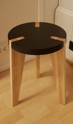 a small black table sitting on top of a hard wood floor next to a door