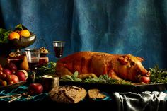 a large piece of meat sitting on top of a table covered in fruit and vegetables