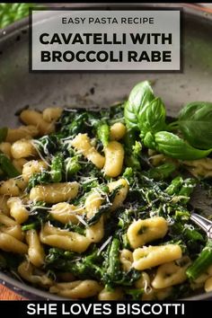 pasta with broccoli and spinach in a skillet on a wooden table