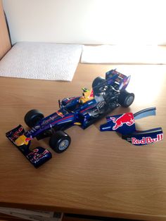 a red bull racing car sitting on top of a wooden table