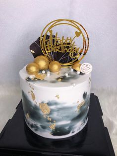 a birthday cake decorated with gold and black decorations