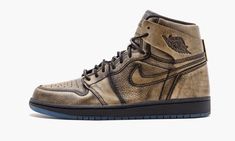 Like Michael Jordan’s storied NBA career, the Air Jordan 1 Retro High “Wings” is layered – the word “layer” here, however, should be taken in a more literal sense. Created in a limited run of 19,400 pairs, the shoe is a visual representation of Jordan’s inner-confidence, as depicted by a gold undertone layer that appears atop of a black leather upper. The details on the shoe are stunning: ‘Wings’ detailing can be seen under the flap on the ankle paneling, the heel sports MJ’s iconic outstretched Air Jordan En Or, Luxury Brown High-top Jordan Shoes, Jordan 1 High Stadium Goods, Gold Air Jordan 1, Jordan 1 Heirloom, Wings Shoes, Wings Black, Wing Shoes, Air Jordan 1 Retro High