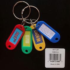 four different colored keychains are shown with a barcode tag attached to them