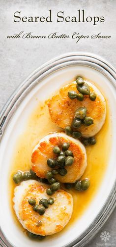 the cover of seared scallops and beans with capers sauce on a white plate