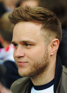 a close up of a person wearing a jacket and looking to the side with a serious look on his face