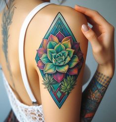 a woman's arm with a colorful flower tattoo on the back of her shoulder